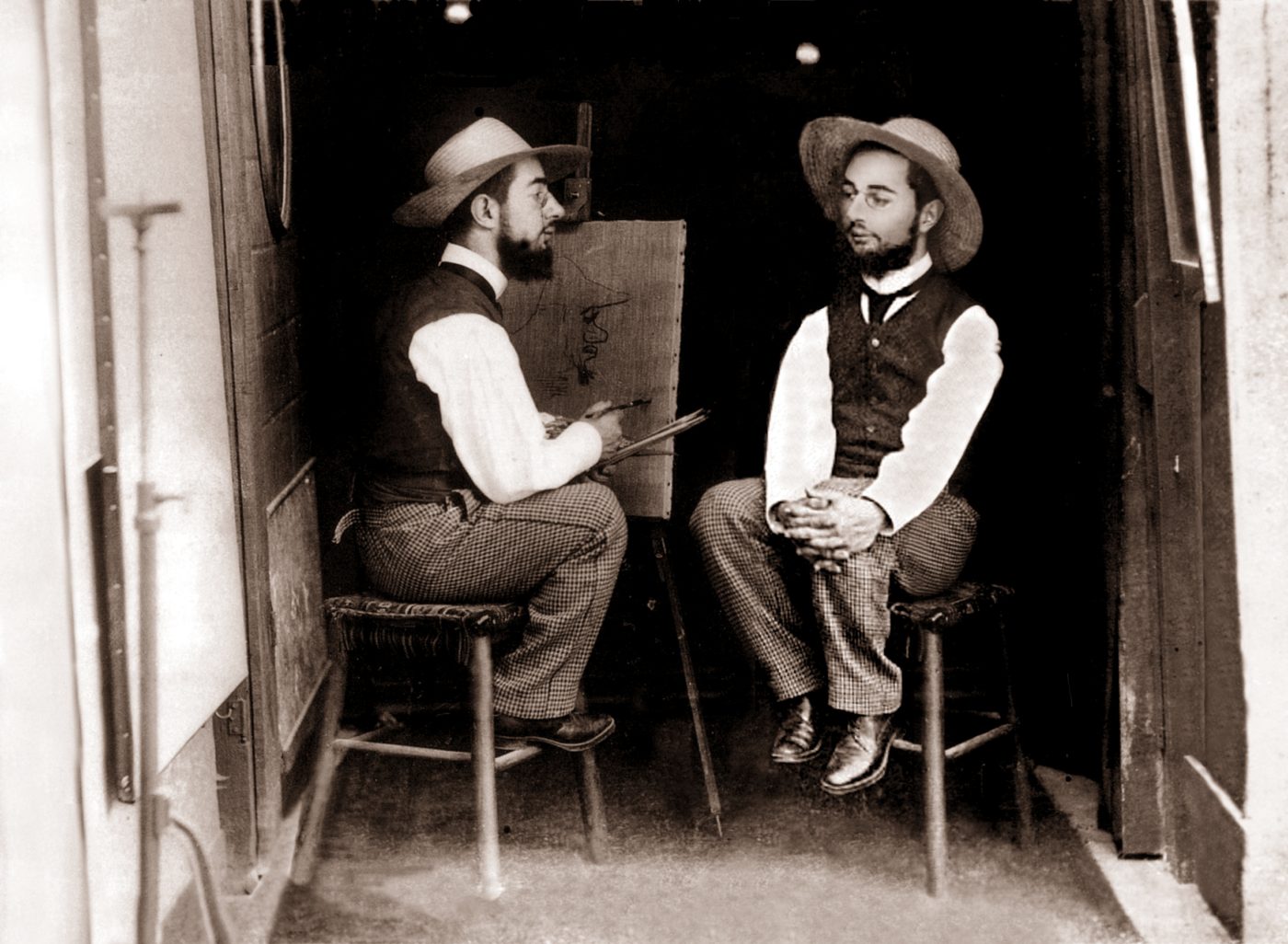 Vintage photograph of a man painting at an easel with his clone as the subject